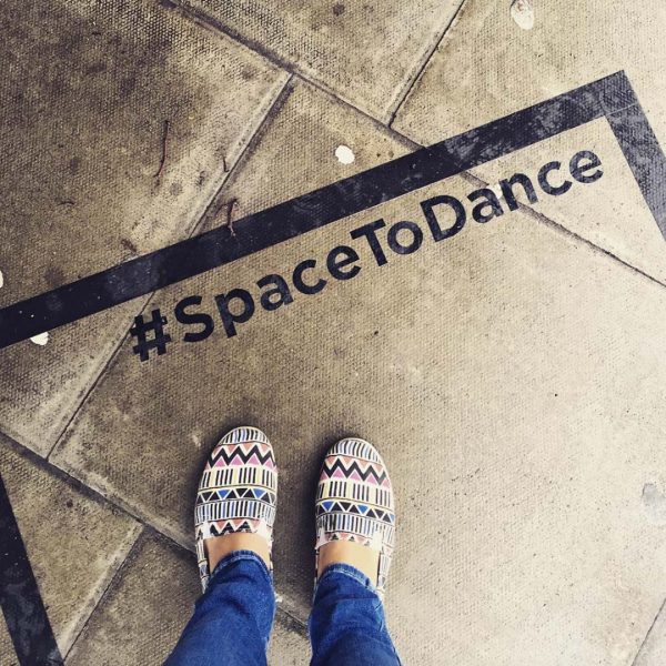 POV photo of a person looking down at the Space to Dance sticker they're standing in.