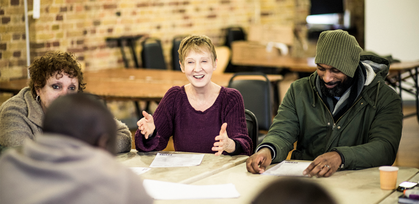 A group of people chatting at a meeting.